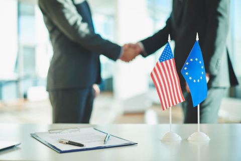 Флаги США и ЕС на столе переговоров